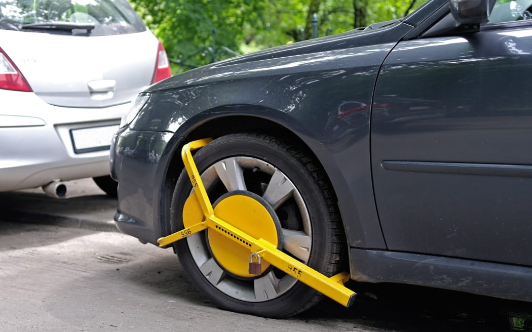 Wheel clamp mounted on parked car
