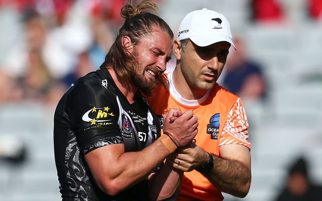 Kieran Foran leaves the filed with a dislocated shoulder in the test against Great Britain.