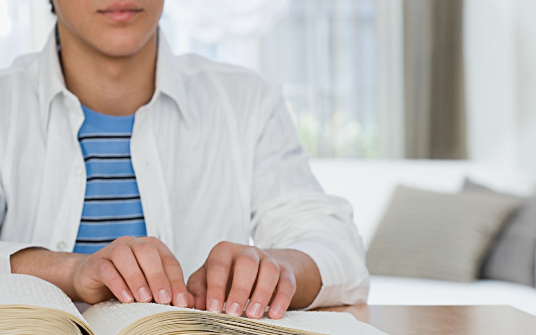 Blind boy reading a braille book
