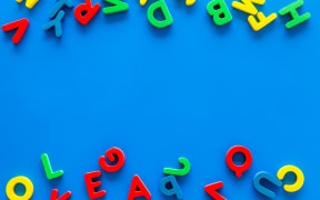 Alphabet for kids concept. English letters in disorder on blue background top view.