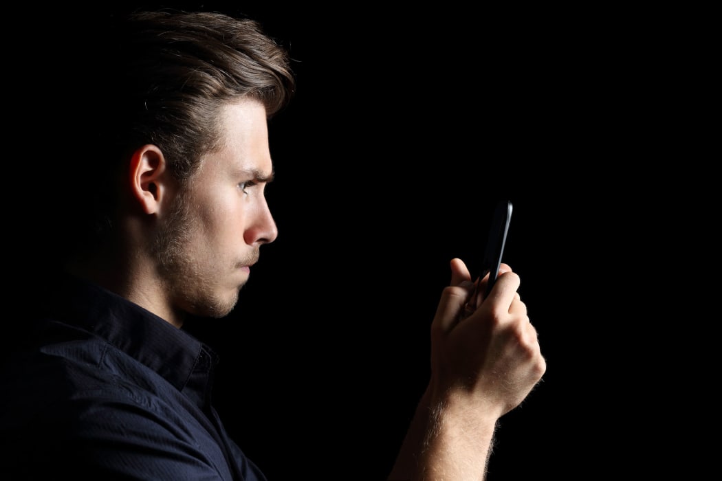 Angry teenager texting on smart phone.