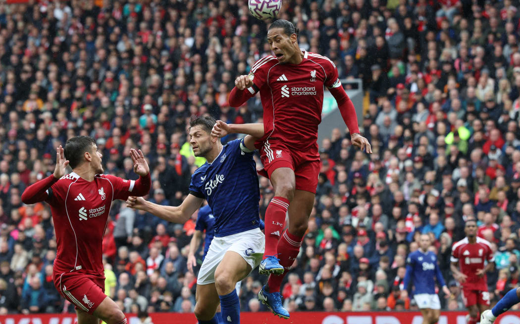 Liverpool defender Virgil van Dijk wins a header against Everton.