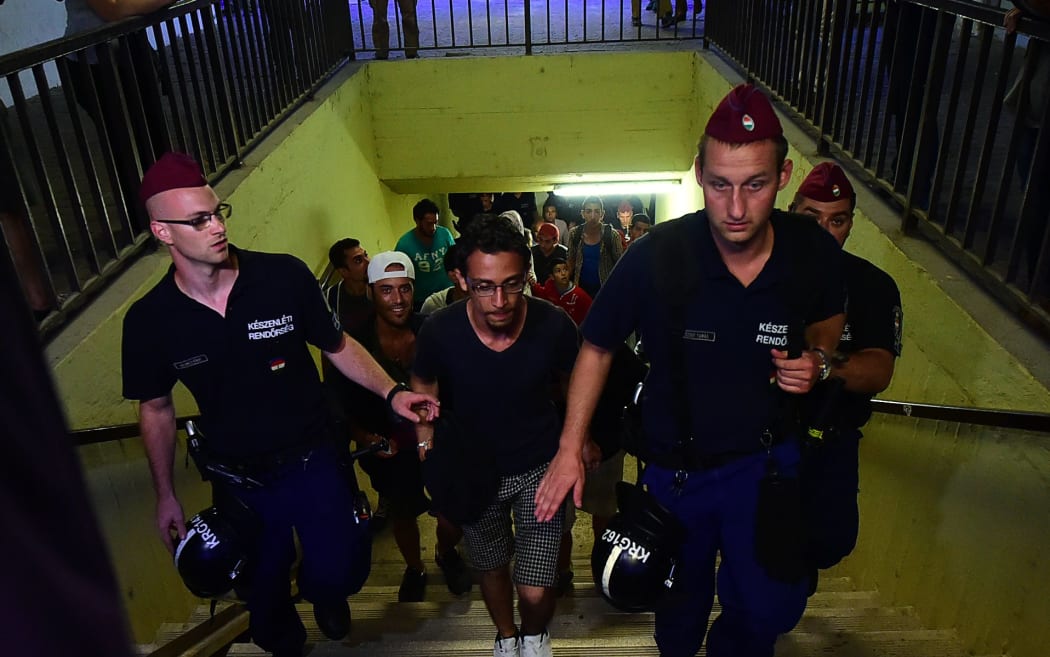 Hungarian police escort refugees from a train they boarded in the hope of reaching western Europe.