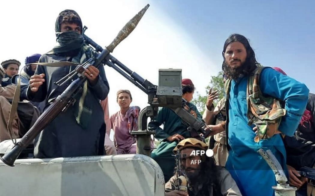 Taliban fighters sit over a vehicle on a street in Laghman province on August 15, 2021. (Photo by - / AFP)