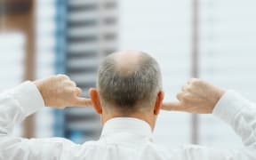 Man putting his fingers in his ears (Photo by Huber & Starke / Image Source / Image Source via AFP)