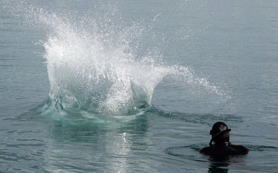 A competitor splashes down in front of safety diver Craig Johnston.