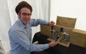 ZIP field team leader Duncan Kay with a new trap that notifies trappers when it's deployed.