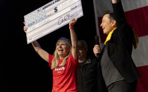 PITTSBURGH, PENNSYLVANIA - OCTOBER 20: SpaceX and Tesla founder Elon Musk awarded Kristine Fishell with a $1 million check during the town hall at the Roxain Theater on October 20, 2024 in Pittsburgh, Pennsylvania. Musk has donated more than $75 million to America PAC, which he co-founded with fellow Silicon Valley venture capitalists and tech businessmen to support Republican presidential nominee, former U.S. President Donald Trump.   Michael Swensen/Getty Images/AFP (Photo by Michael Swensen / GETTY IMAGES NORTH AMERICA / Getty Images via AFP)