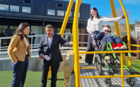Education Minister Erica Stanford and Sara Cohen School principal Matthew Tofia check out the school's new wheelchair swing.