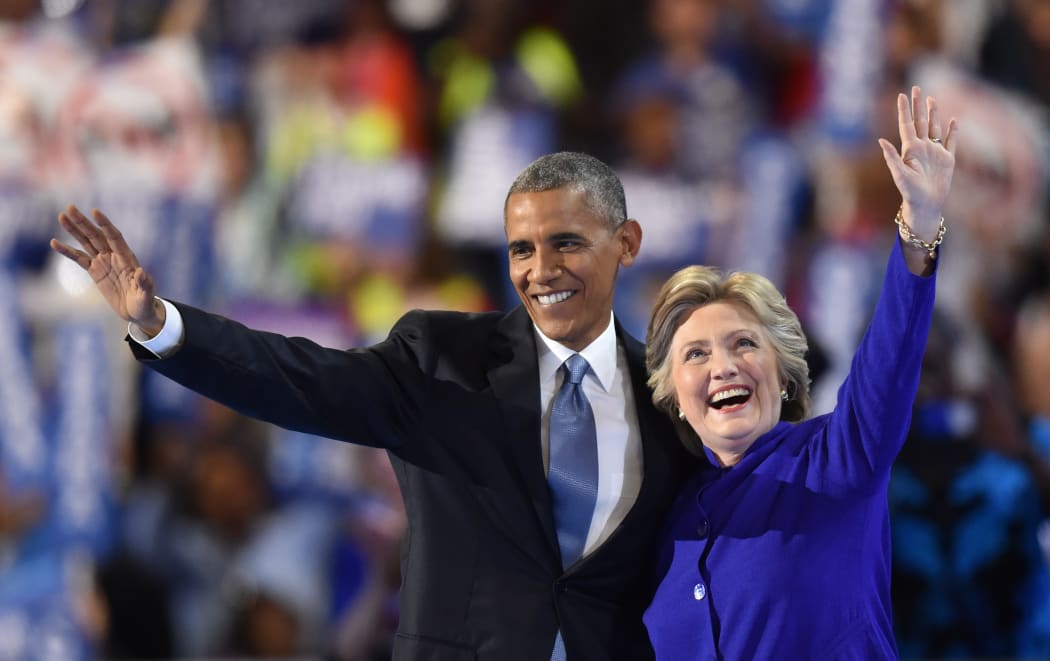 US President Barack Obama, left, waves with US presidential nominee Hillary Clinton during the third night of the Democratic National Convention in Philadelphia on 27 June (US time).