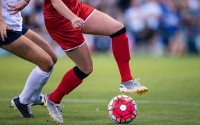 women playing in a soccer game on a soccer field