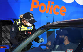 Police inspect driver licences at a checkpoint in the locked-down suburb of Broadmeadows in Melbourne on July 2, 2020.