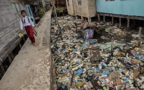 Household garbage disposed of into the sea at low tide accumulates under the houses of residents in the Riau island of Batam, Indonesia.