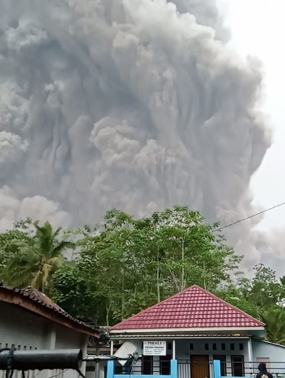 This handout picture taken and released on December 4, 2021 by Indonesia's National Board for Disaster Management (BNPB) shows Semeru volcano spewing ash into the air during an eruption as seen from Lumajang. M