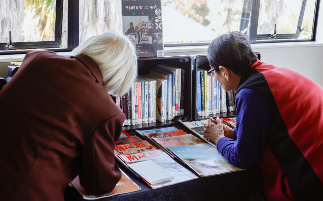 Elders choosing books at Deverton House Rest Home