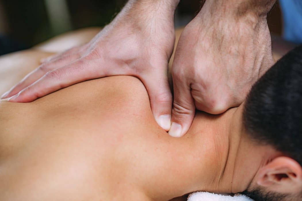 Physiotherapist massaging patient's shoulder. (Photo by MICROGEN IMAGES/SCIENCE PHOTO LI / SMD / Science Photo Library via AFP)