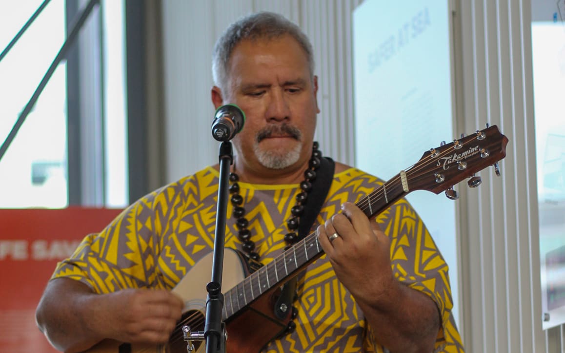 Ena Manureia plays guitar. He's on a mission to save the Mangarevan language