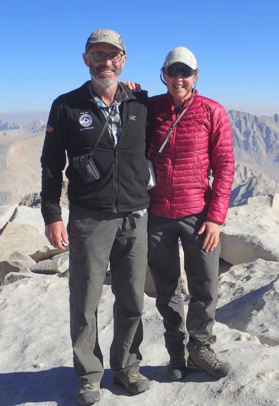 A photo of Don Bogie with his wife, Peg Gosden, on Mount Whitney in the United States, with other mountains behind them.