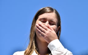 Former government staffer Brittany Higgins, who alleged publicly last month that she had been raped by a colleague in a minister's office in 2019, reacts as she speaks before protesters during a rally against sexual violence.