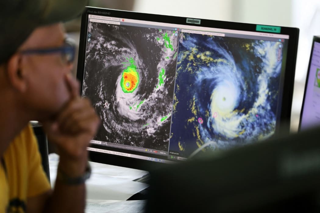 Forecasters watch satelitte control screens as they monitor Cyclone Freddy at the France weather station, Meteo France, in Saint Denis de la Reunion, on the French overseas island of La Reunion on February 20, 2023. (Photo by Richard BOUHET / AFP)