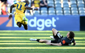 Angel Torres of the Mariners is tackled by Matt Sheridan of The Phoenix during the A-League Men Round 23 match between the Central Coast Mariners and Wellington Phoenix at Industree Group Stadium in Gosford, Saturday, April 6, 2024. (AAP Image/Dan Himbrechts/ Photosport )