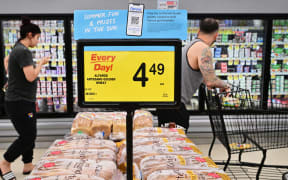 People shop at a grocery supermarket in Alhambra, California, on 13 July, 2022.