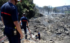 French firefighters extinguish a fire after brushfire hit the countryside around Saint Gilles, on June 29, 2019