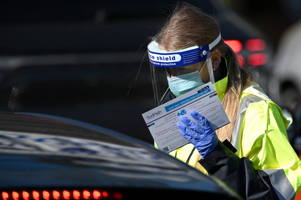 Health staff register a resident at a Covid-19 coronavirus drive-through testing site on Bondi Beach in Sydney on 17 June 2021, after four positive cases were reported.