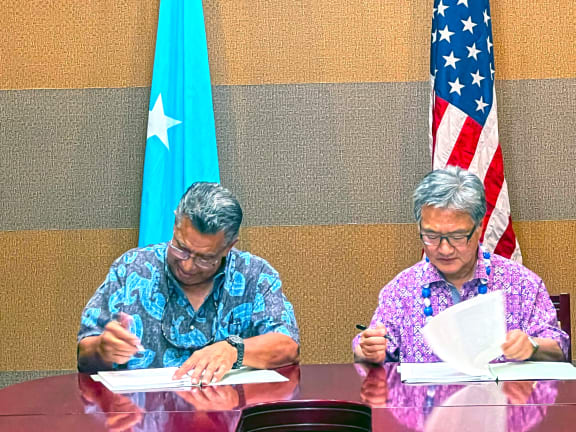 FSM Chief Negotiator Leo A. Falcam, Jr., left, joins with Special Presidential Envoy Joseph Yun on Monday this week in Pohnpei to initial a nearly final version of the new 20-year funding agreement for extending the Compact of Free Association.