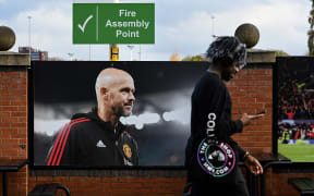 A visitor walks past a picture of newly sacked Manchester United's Dutch manager Erik ten Hag, outside Old Trafford, in Manchester.