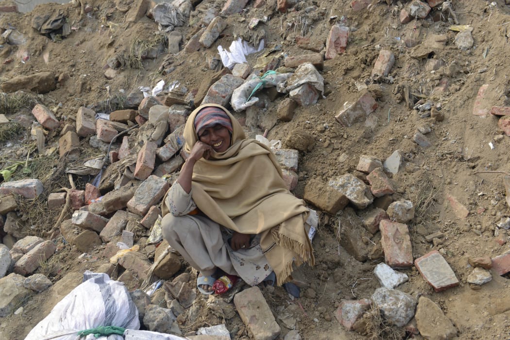 Pakistani woman Nasreen Bibi waits for news of her son missing under the rubble.