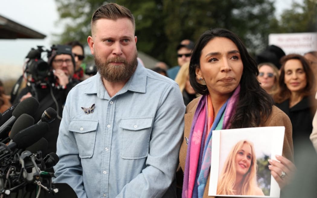Sky Roberts (L), brother of Virginia Giuffre, who was abused by Jeffrey Epstein, and his wife Amanda Roberts hold up a photo of Giuffre during a news conference on the Epstein Files Transparency Act outside the U.S. Capitol on November 18, 2025 in Washington, DC. Virginia.