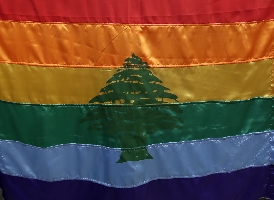 A gay pride flag bearing the cedar tree of the Lebanese flag carried by a human rights activists during an anti-homophobia rally in Beirut in 2013.