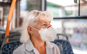 Caucasian woman in a protective mask sits in public transport at a distance of 2 m from other passengers. Protection and prevention covid 19, Coronavirus