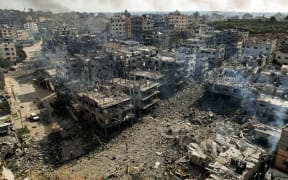 This picture taken on October 11, 2023 shows an aerial view of buildings destroyed by Israeli air strikes in the Jabalia camp for Palestinian refugees in Gaza City. Israel declared war on Hamas on October 8 following a shock land, air and sea assault by the Gaza-based Islamists. The death toll from the shock cross-border assault by Hamas militants rose to 1,200, making it the deadliest attack in the country's 75-year history, while Gaza officials reported more than 900 people killed as Israel pounded the territory with air strikes. (Photo by Yahya HASSOUNA / AFP)