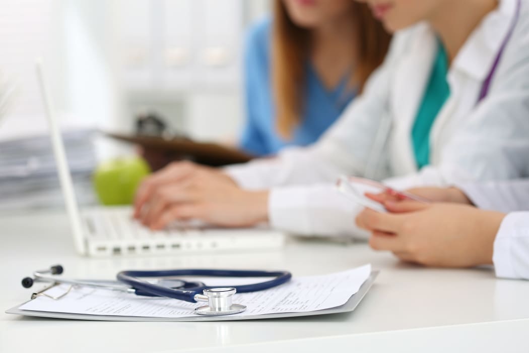 Healthcare staff, doctors, nurse, working on laptop.
