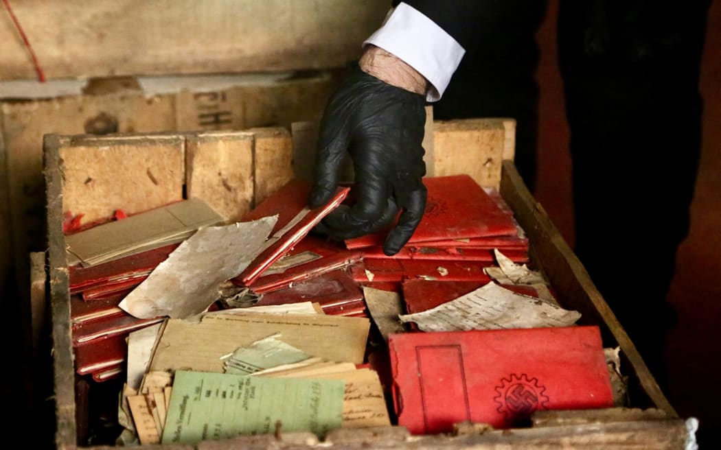 Handout picture released on May 11, 2025 by Argentina's Supreme Court showing authorities checking Nazi documentation found in boxes stored at the basement of the Justice Palace, in Buenos Aires. Argentina's justice system found hundreds of documents and membership cards for Nazi organisations in seven boxes stored in the Supreme Court archive relating to a case initiated in 1941. The boxes were opened on Friday 9 and their contents were kept to be classified, documented, and preserved by order of the supreme court to investigate whether they could provide relevant information regarding events linked to the Holocaust or the escape of Nazis to Argentina. (Photo by Handout / ARGENTINA'S SUPREME COURT OF JUSTICE / AFP) / RESTRICTED TO EDITORIAL USE - MANDATORY CREDIT "AFP PHOTO / ARGENTINA'S SUPREME COURT OF JUSTICE" - NO MARKETING - NO ADVERTISING CAMPAIGNS - DISTRIBUTED AS A SERVICE TO CLIENTS