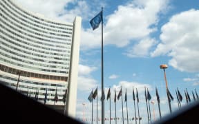 The flag of the International Atomic Energy Agency (IAEA) flutters in front of the IAEA building in Vienna on July 10, 2019.