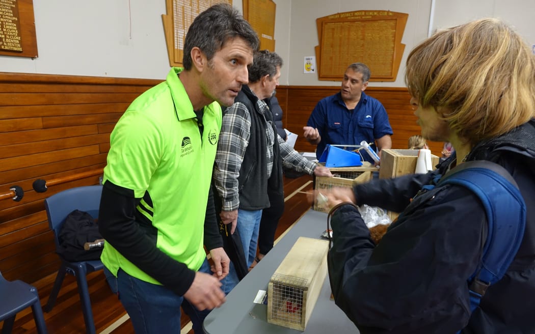 Council officers explain how to use the traps at Oakura Hall.