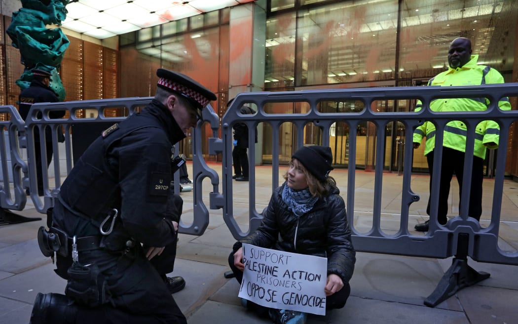 A handout photograph taken on and released by Prisoners for Palestine in London on 23 December, 2025 shows Swedish activist Greta Thunberg before her arrest by Police officers outside the offices of Aspen Insurance at Plantation Place on Fenchurch Street.