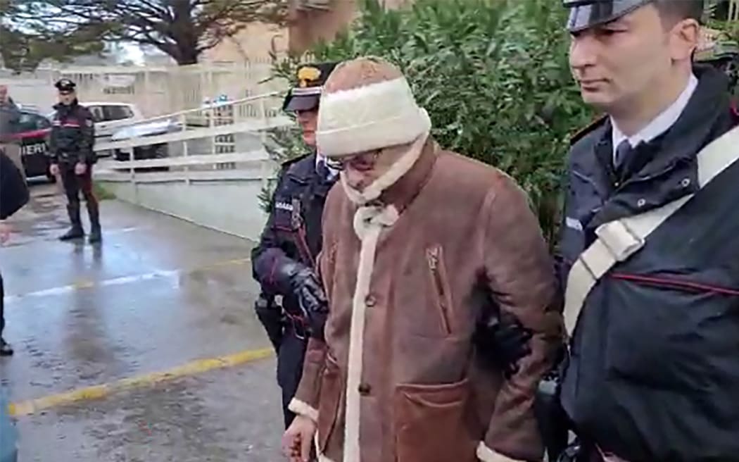 This handout video grab taken and released by the Italian Carabinieri Press Office on January 16, 2023 shows the arrest by Carabinieri of the Italy's top wanted mafia boss, Matteo Messina Denaro in Palermo, in his native Sicily after 30 years on the run. - Italian anti-mafia police caught Sicilian godfather Matteo Messina Denaro on January 16, 2023, ending a 30-year manhunt for Italy's most wanted fugitive. The mobster was nabbed "inside a health facility in Palermo, where he had gone for therapeutic treatment", special operations commander Pasquale Angelosanto said in a statement released by the police. (Photo by Handout / ITALIAN CARABINIERI PRESS OFFICE / AFP) / RESTRICTED TO EDITORIAL USE - MANDATORY CREDIT "AFP PHOTO / HANDOUT / ITALIAN CARABINIERI PRESS OFFICE " - NO MARKETING NO ADVERTISING CAMPAIGNS - DISTRIBUTED AS A SERVICE TO CLIENTS