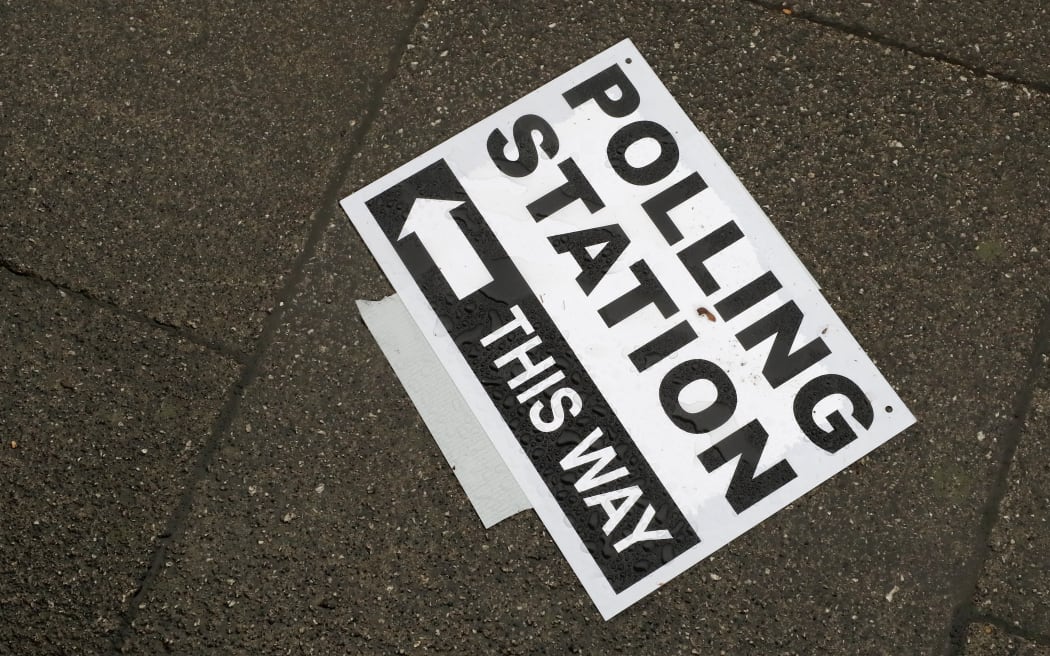 FILE - In this Thursday, Dec. 12, 2019 file photo, a polling station signpost lies on the pavement, in Twickenham, England.  The United Kingdom will hold its first national election in almost five years on Thursday, with opinion polls suggesting that Prime Minister Rishi Sunak’s Conservative Party will be punished for failing to deliver on promises made during 14 years in power.  (AP Photo/Frank Augstein, File)