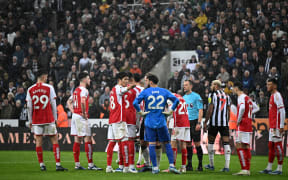 Referee Stuart Attwell and players wait as the VAR looks at the reasons for allowing or not, the opening goal.