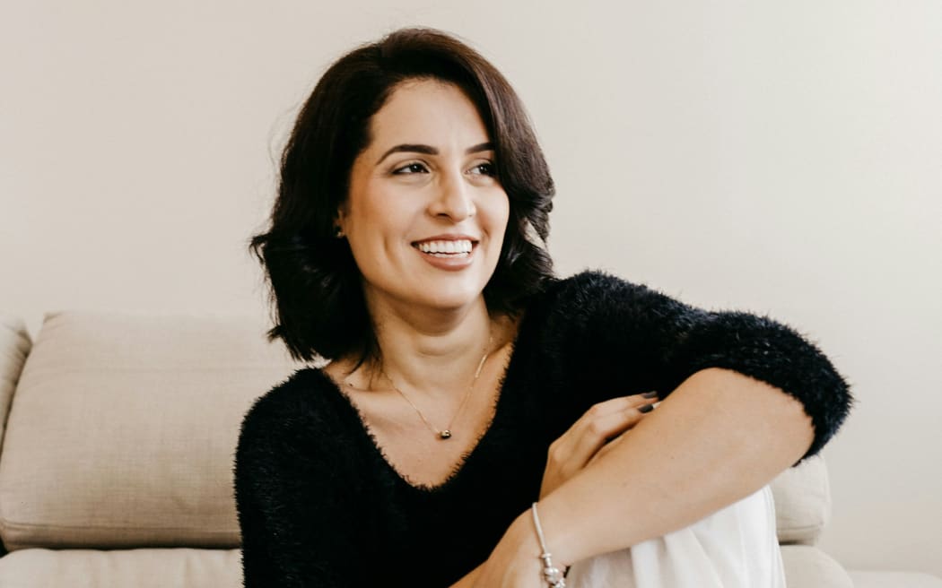 A smiling woman in a black top.