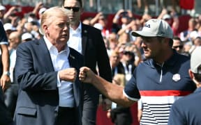 US President Donald Trump fist-bumps US golfer Bryson DeChambeau as he attends the 45th Ryder Cup at Bethpage Black Course in Farmingdale, New York, September 26, 2025. (Photo by Mandel NGAN / POOL / AFP)
