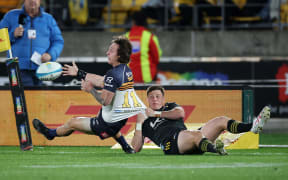 Brumbies' Corey Toole tackled by Hurricanes Cameron Roigard 2023.