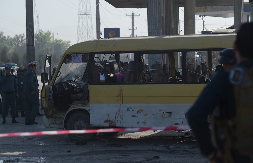Afghan policemen look at the site of a suicide attack to have hit a minibus carrying foreign security guards in Kabul.