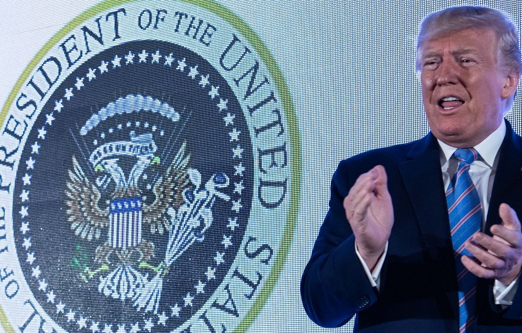 US President Donald Trump arrives to address the Turning Point USAs Teen Student Action Summit 2019 in Washington, DC. Trump stands in front of a presidential seal manipulated to make the eagle resemble Russia's two-headed version.