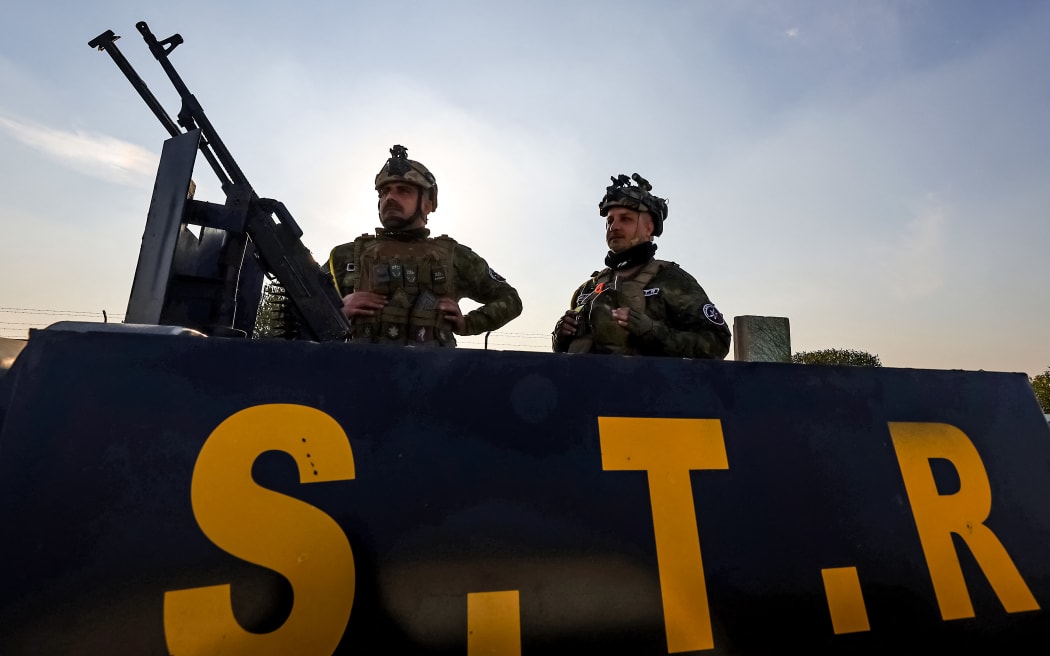 Members of the Iraqi security forces stand guard atop an armoured vehicle in Baghdad on January 4, 2024. A US strike in Baghdad on January 4 killed a military commander of the PMF, an ex-paramilitary faction of the grouping said, with an Iraqi security official reporting two deaths in a drone attack. Harakat al-Nujaba, one of the PMF's factions, said in a statement that "the deputy commander of operations for Baghdad, Mushtaq Talib al-Saidi", had been "martyred in a US strike".