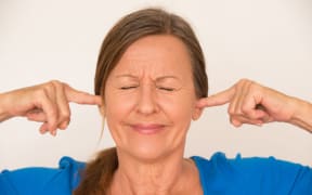 woman blocking her ears
